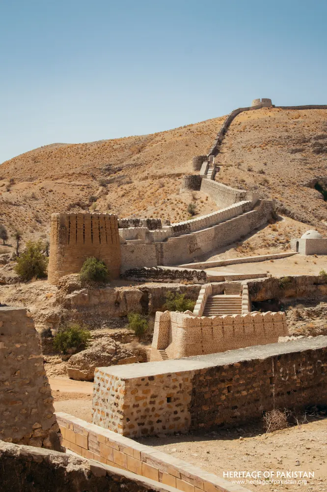 Brick tower and stepped wall climbing a dry hillside