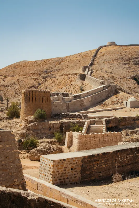 Brick tower and stepped wall climbing a dry hillside