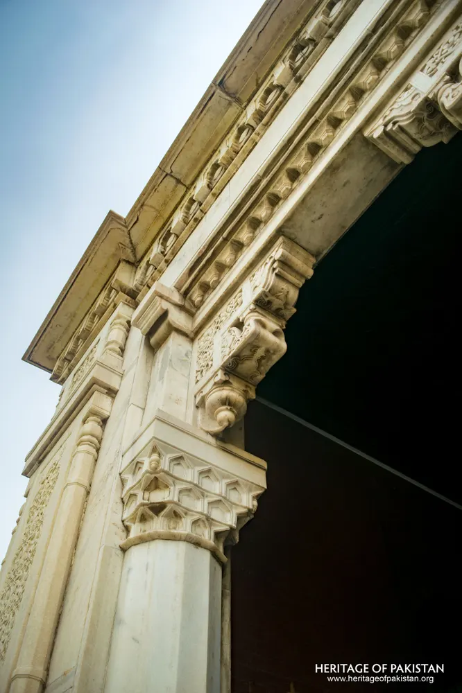 White marble column capital and carved cornice, seen from below
