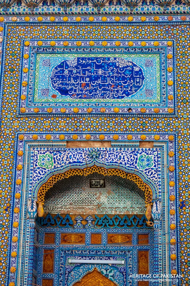 Calligraphic tile cartouche over an arched honeycombed niche