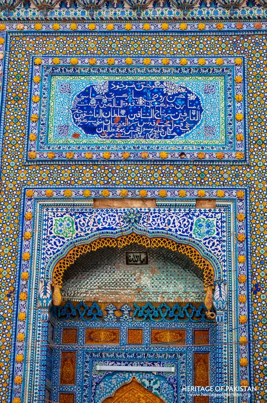 Calligraphic tile cartouche over an arched honeycombed niche
