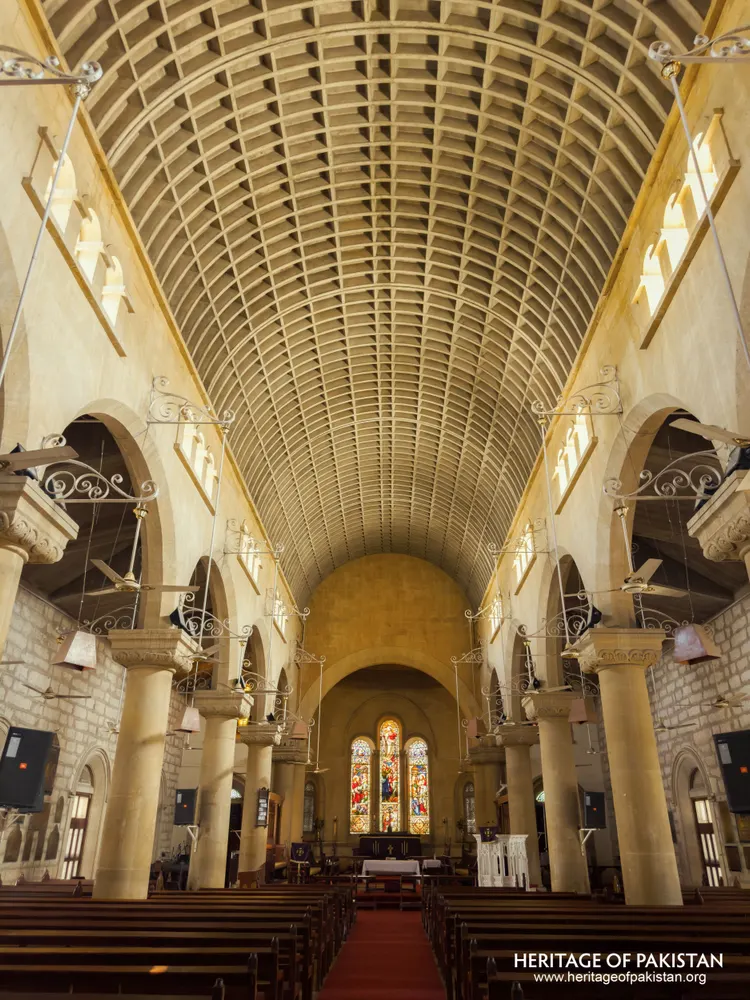 Upward-angled view of Holy Trinity Church's vaulted ceiling and stained-glass apse