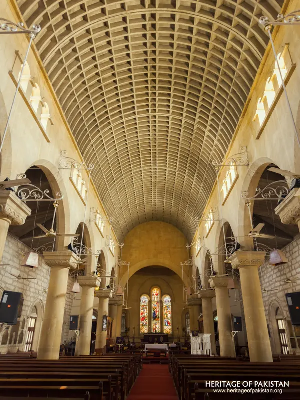 Upward-angled view of Holy Trinity Church's vaulted ceiling and stained-glass apse