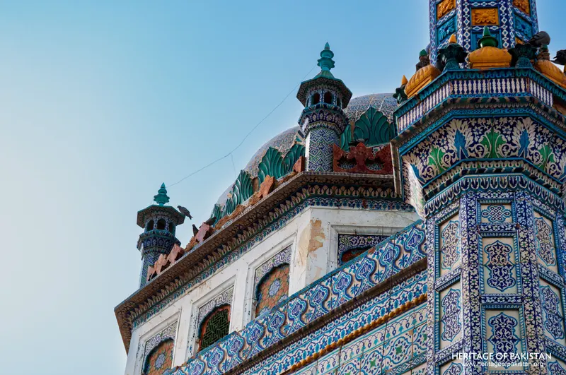 Corner turrets and tiled cornice below the shrine's green domes