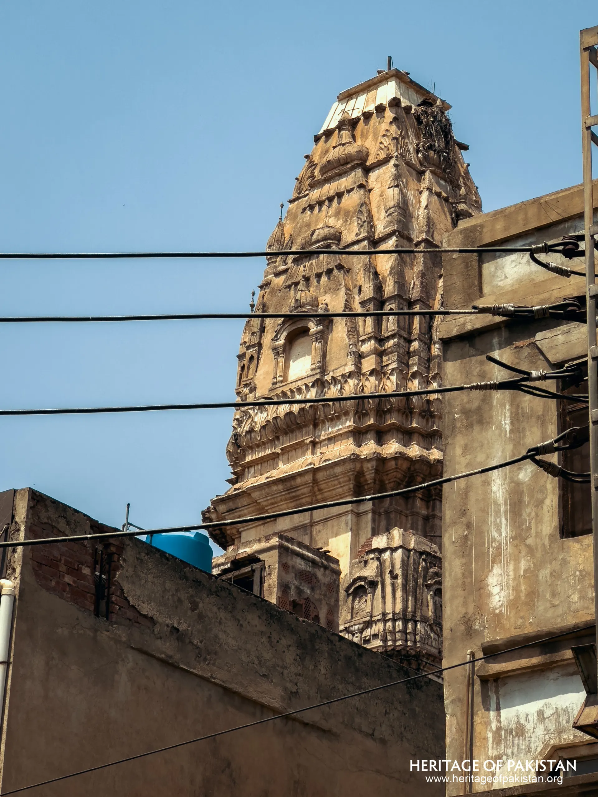 A slender roofline rises above Anarkali's rooftops — the tomb of Lahore's first Sultan, easy to miss from the street.
