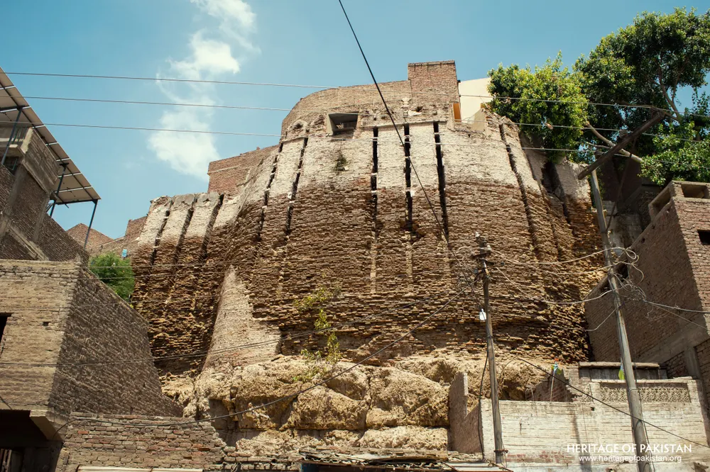 Stepped bastion of Pakka Qila towering above shuttered market shops at its base