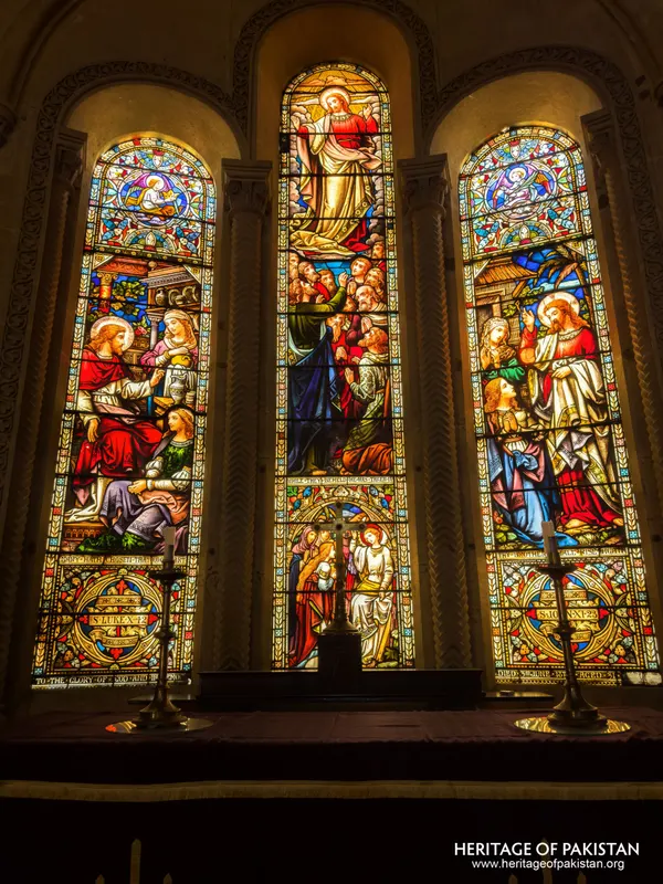 Stained-glass triptych window depicting biblical scenes above the altar at Holy Trinity Church