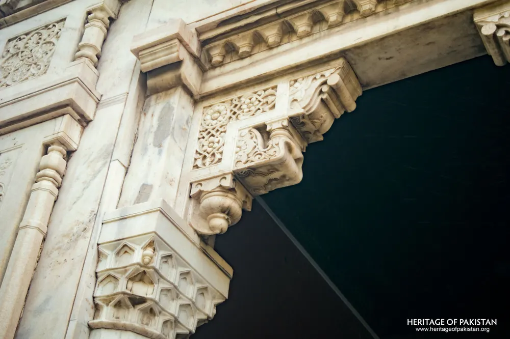 Close-up of a carved marble bracket with floral and scroll relief