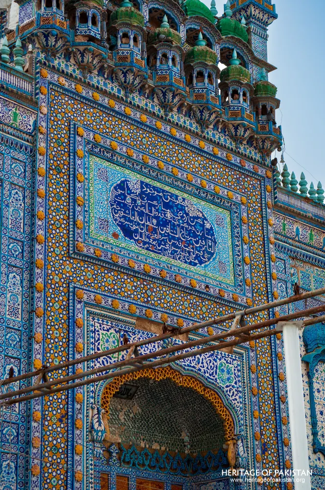 Tiled shrine wall with a calligraphic panel and a niche below