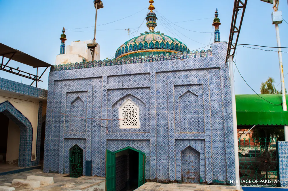 Tomb chamber of the shrine with a green dome and blue-tiled walls