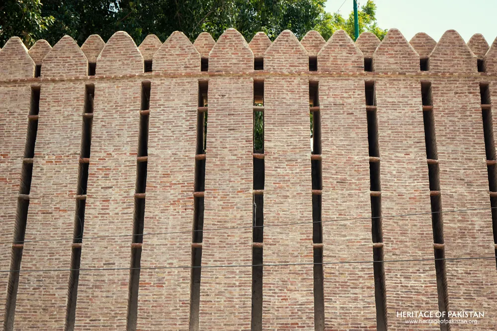 Close-up of Pakka Qila's crenellated brick rampart showing vertical buttress ribs
