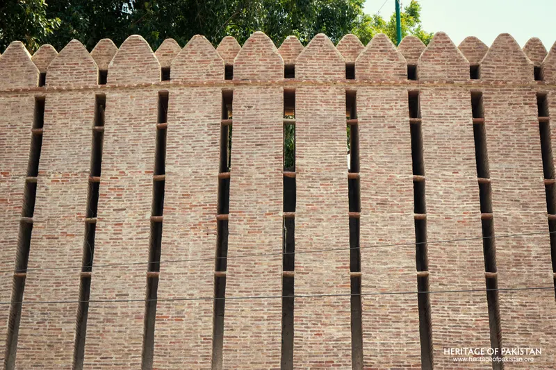 Close-up of Pakka Qila's crenellated brick rampart showing vertical buttress ribs