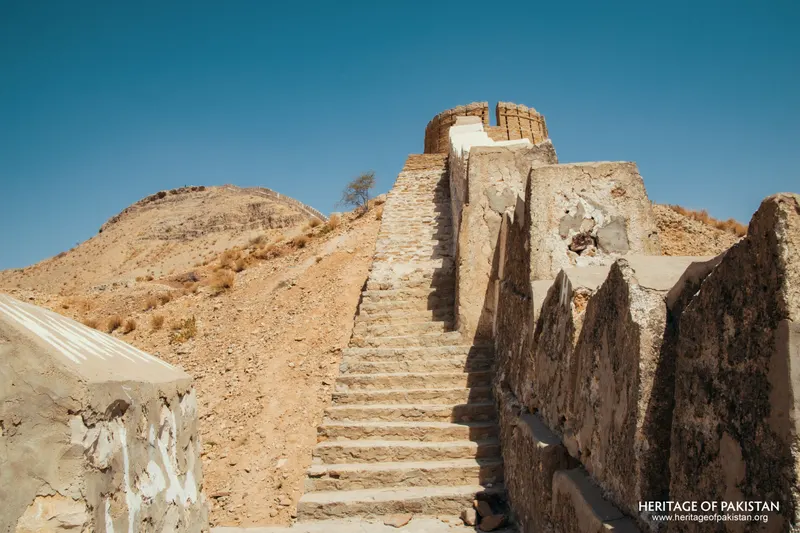 Stone staircase leading up to a cylindrical bastion on a rocky hillside