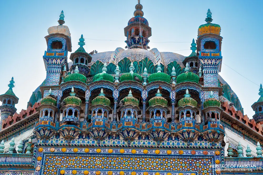 Green-glazed domes and honeycombed tiers crowning the shrine roof