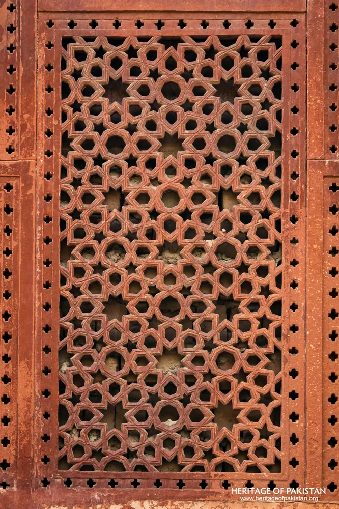 Red sandstone jali screen with geometric star pattern