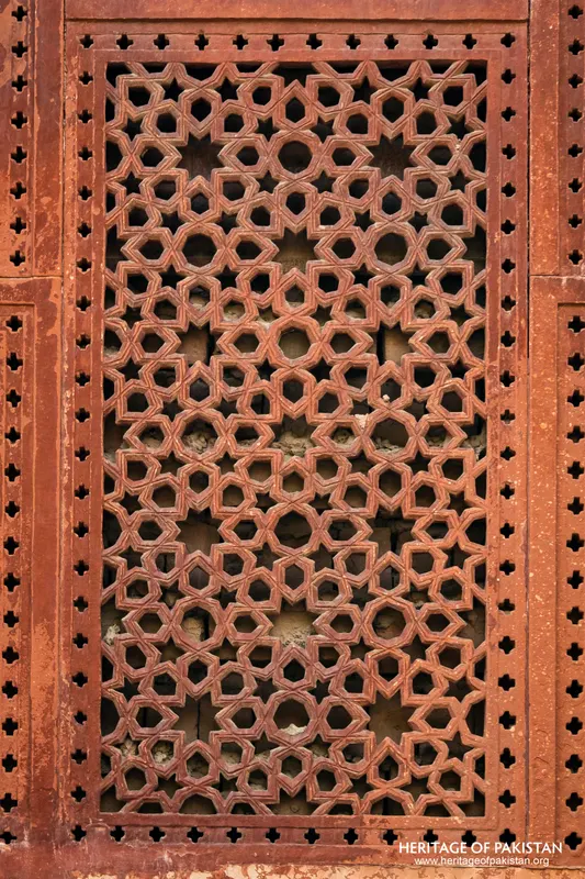Red sandstone jali screen with geometric star pattern