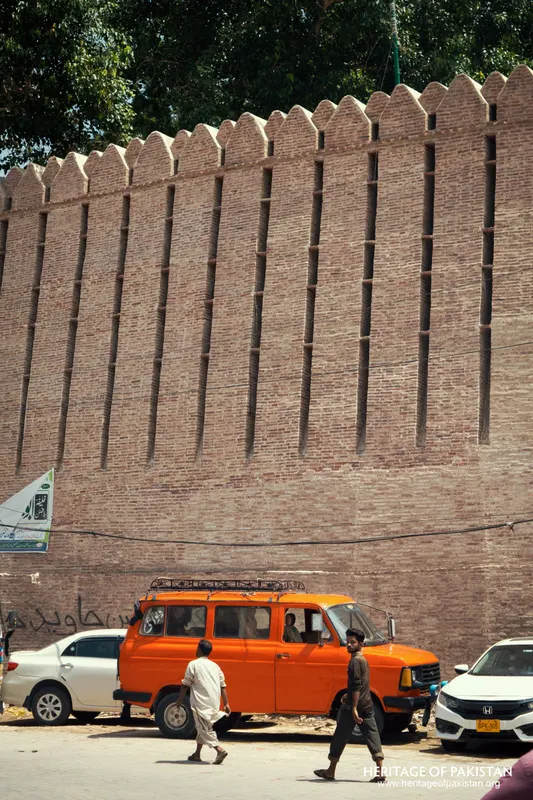 Towering crenellated brick rampart of Pakka Qila beside a busy Hyderabad street