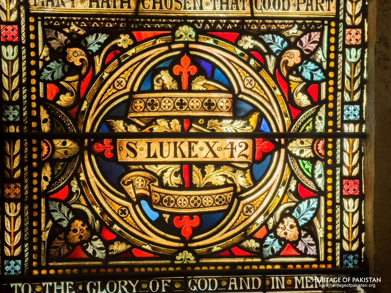 Close detail of an inscribed medallion reading 'S. Luke X. 42' in the stained-glass window at Holy Trinity Church