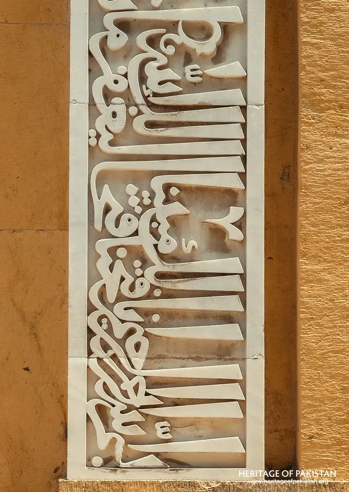 Close-up of a white marble calligraphy panel in raised relief