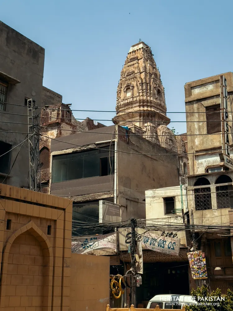 Ornate stone spire rising above low urban rooftops