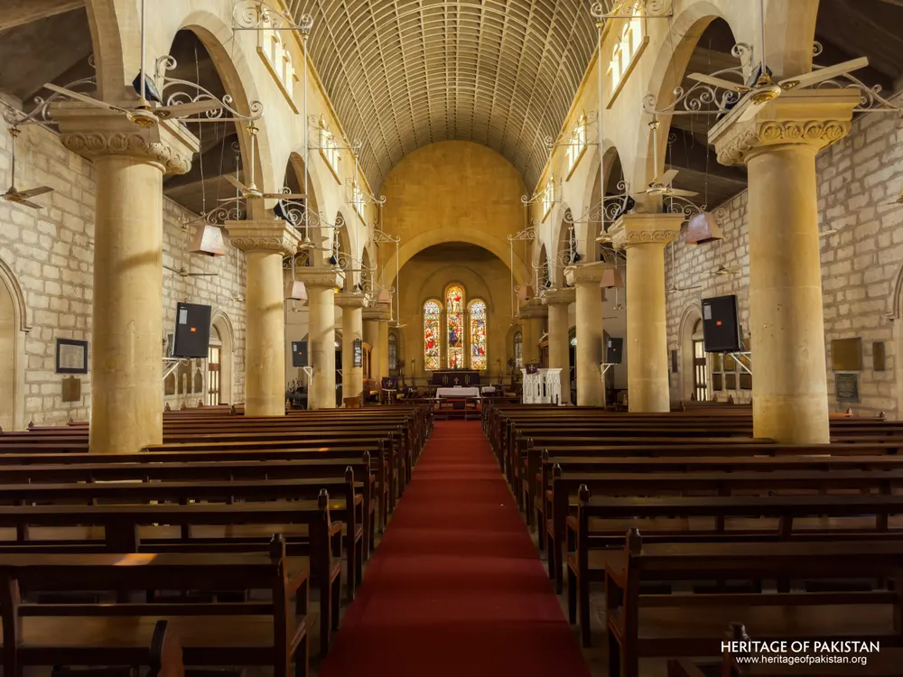 Wide view of Holy Trinity Church's sandstone nave with hanging light fixtures