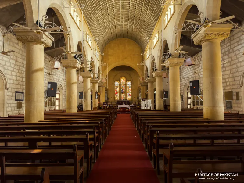 Wide view of Holy Trinity Church's sandstone nave with hanging light fixtures