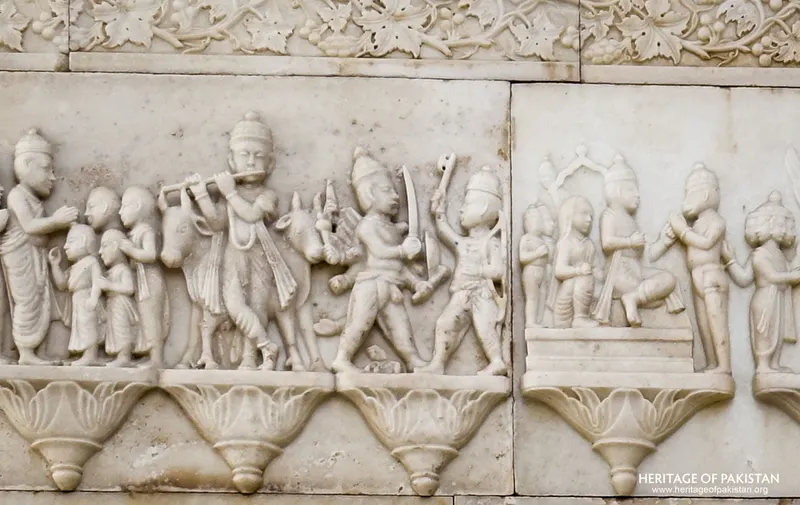 Relief carving of a flute-playing figure with cattle and warriors, Krishna-themed frieze panel at Sadhu Belo Temple