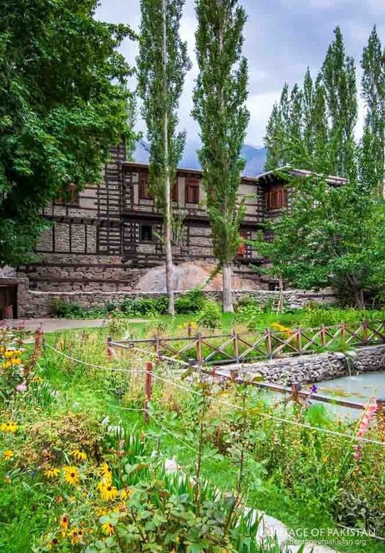 Traditional timber construction rises beyond Shigar Fort's irrigated gardens.