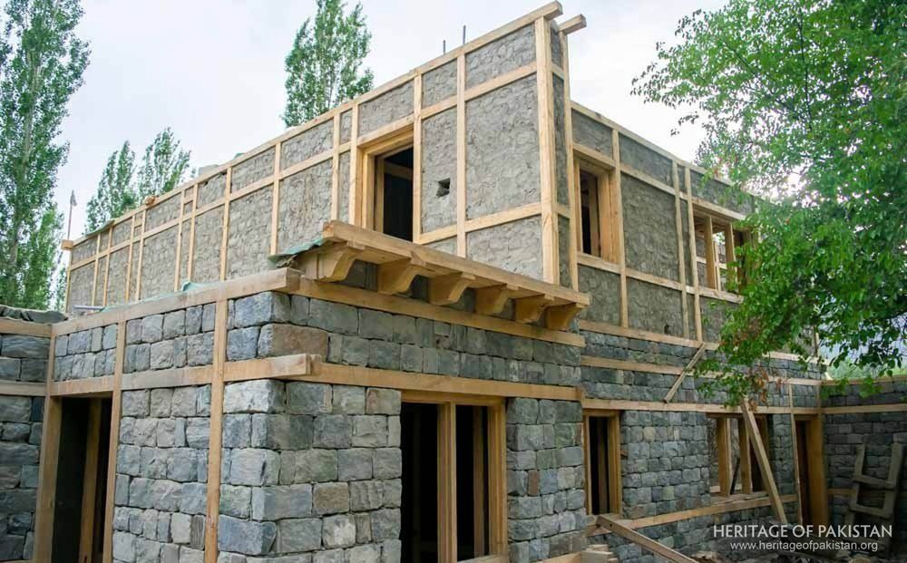 Traditional timber-lacing technique strengthens stone walls during construction.