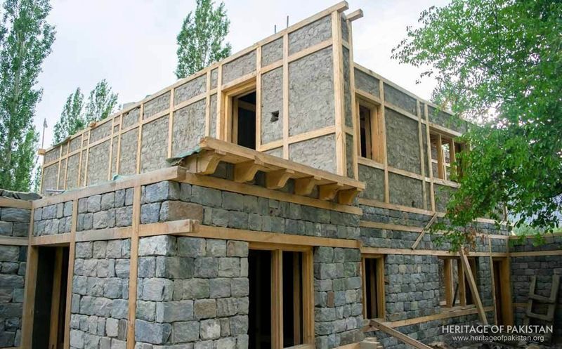Traditional timber-lacing technique strengthens stone walls during construction.