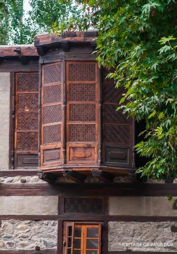 Intricate timber screens frame a projecting window alcove.