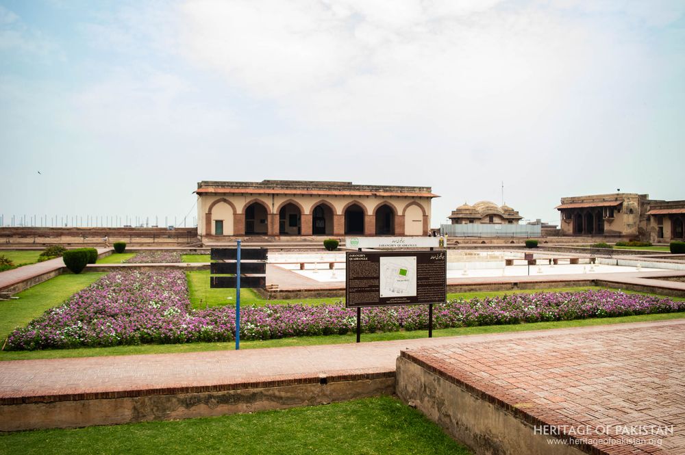 A tranquil courtyard garden with flowering beds frames the historic structure's elegant