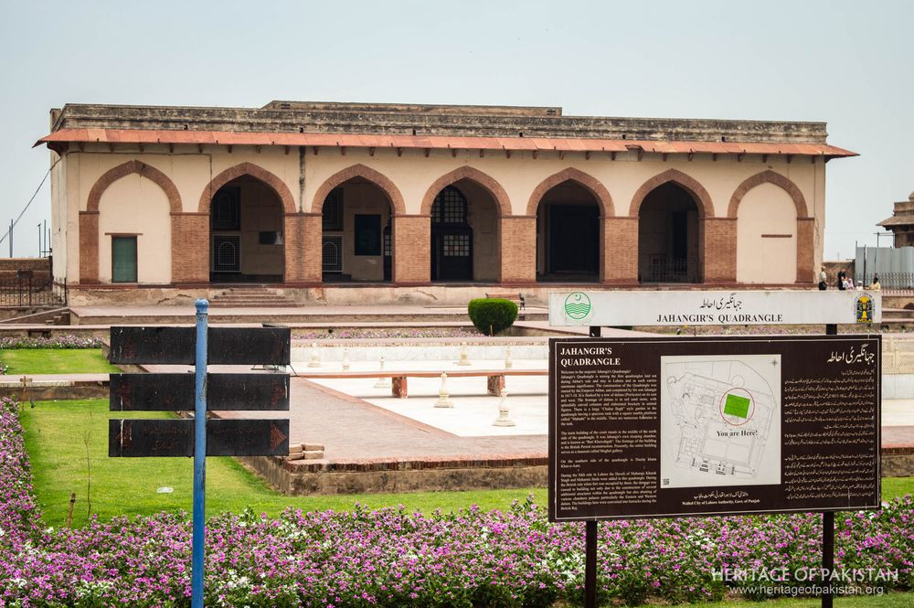 Ornamental arches frame an interpretive display set within gardens and open ground.