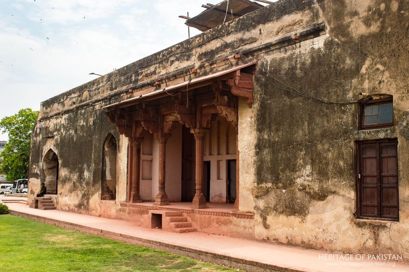 Deteriorating eastern portico with traditional arched openings and columns.